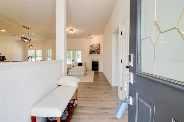 a view of a hallway with wooden floor windows and a living room