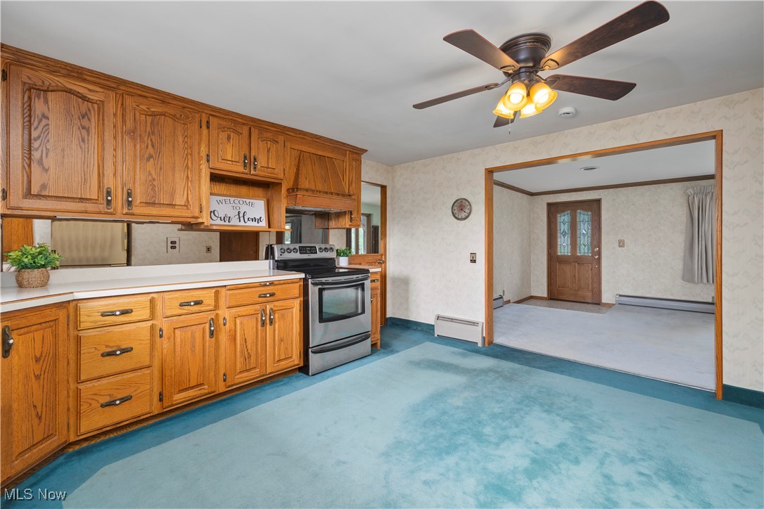 144 Substation Road Brunswick, OH 44212 - Photo 12 of 43 Kitchen with electric stove, baseboard heating, wallpapered walls, carpet floors, and light countertops