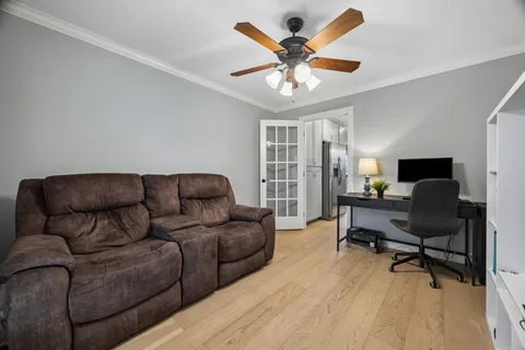 a living room with furniture and a ceiling fan