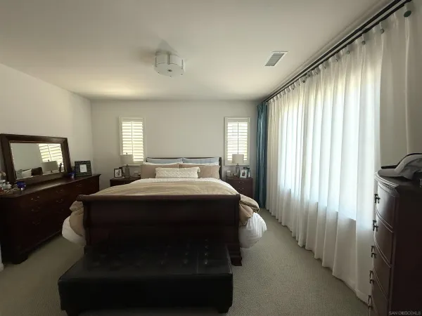a spacious bedroom with a bed and a television