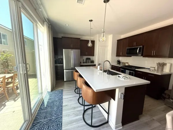 a kitchen with stainless steel appliances kitchen island a sink a stove and a refrigerator