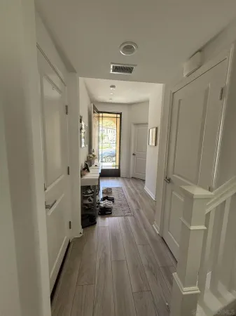 a view of a hallway view with a wooden floor and a sink