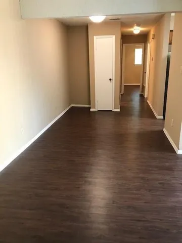 a view of a room with wooden floor and brick walls