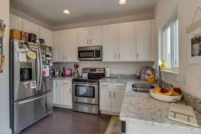 a kitchen with stainless steel appliances granite countertop a refrigerator stove and sink