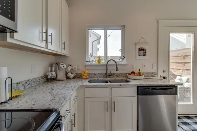 a kitchen with stainless steel appliances granite countertop a sink stove and cabinets