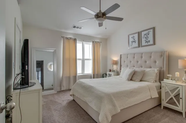 a bedroom with a large bed and a chandelier