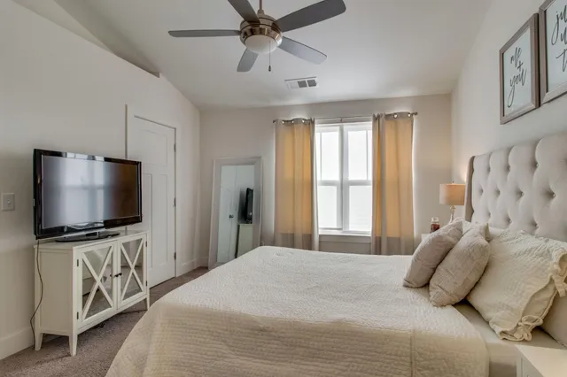a bedroom with a large bed and a flat screen tv