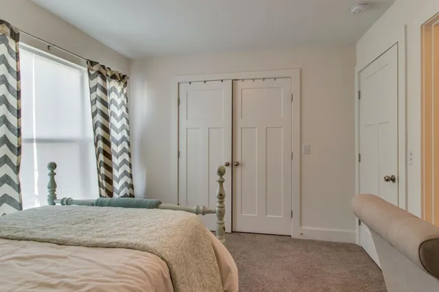 a bedroom with a bed and a window