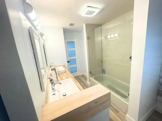 a bathroom with a sink a mirror and a shower