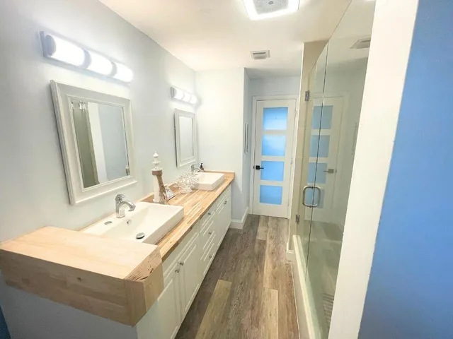 a bathroom with a sink a mirror and a shower