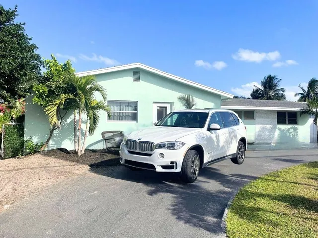 a white house covered with tall trees