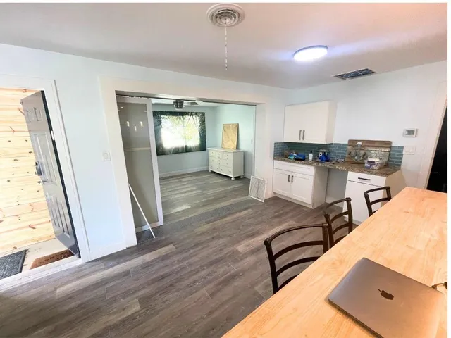 a view of a kitchen with sink microwave and cabinets