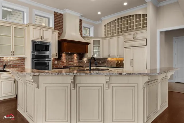 a kitchen with stainless steel appliances granite countertop a sink and cabinets