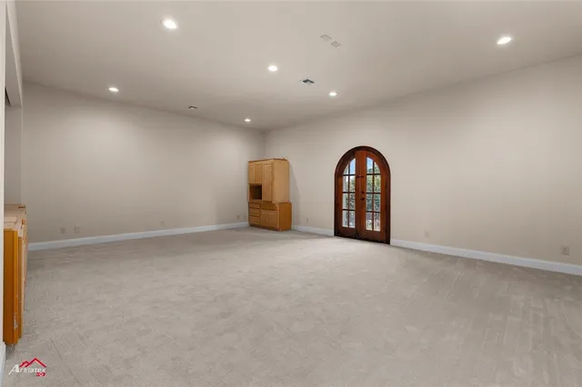 a view of an empty room and chandelier fan