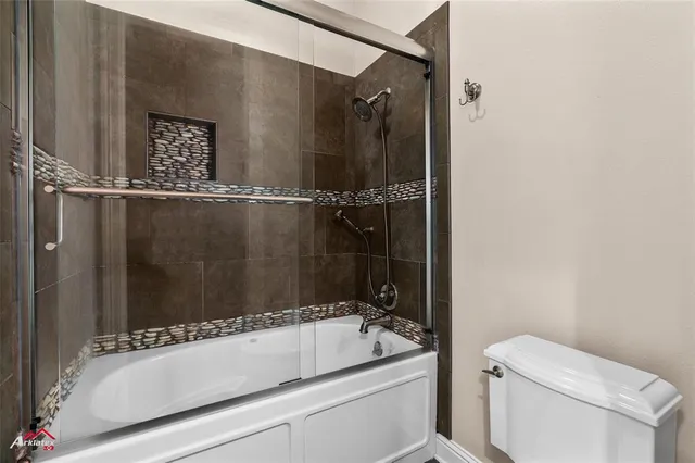 a bathroom with a granite countertop sink toilet a mirror and shower