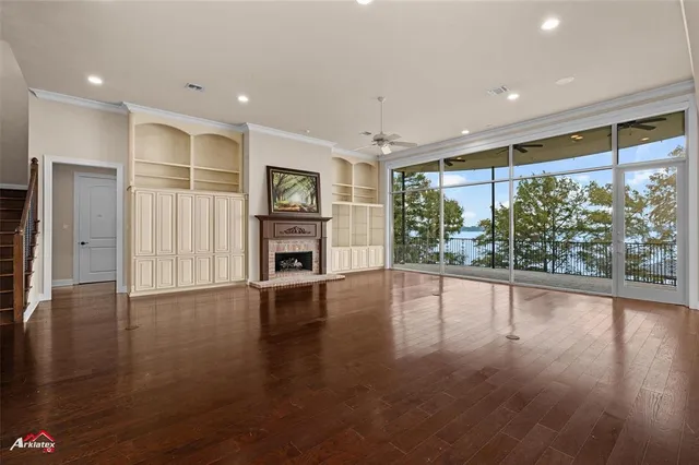 a view of empty room with wooden floor and fireplace
