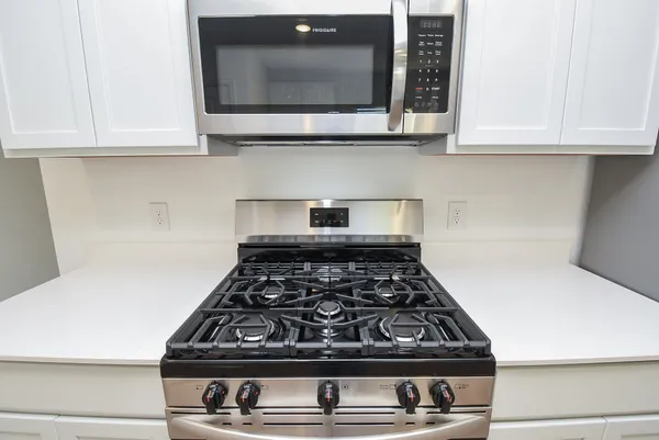 a kitchen with wooden cabinets and a stove top oven