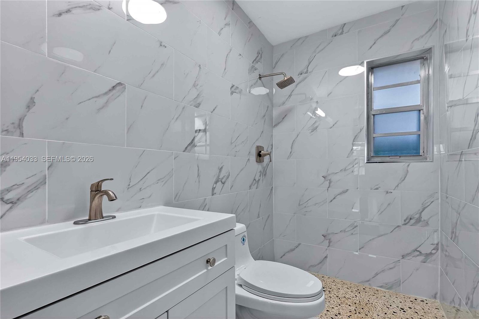 2399 Southwest 26th Lane Miami, FL 33133 - Photo 25 of 39 a bathroom with a sink a toilet and shower