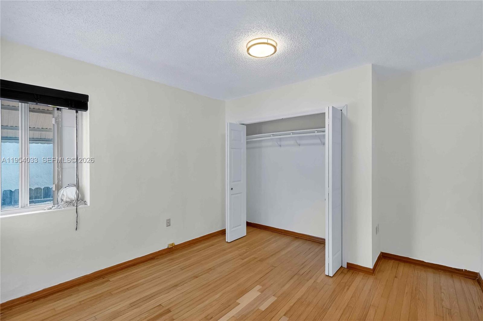 2399 Southwest 26th Lane Miami, FL 33133 - Photo 28 of 39 a view of an empty room with wooden floor and a window