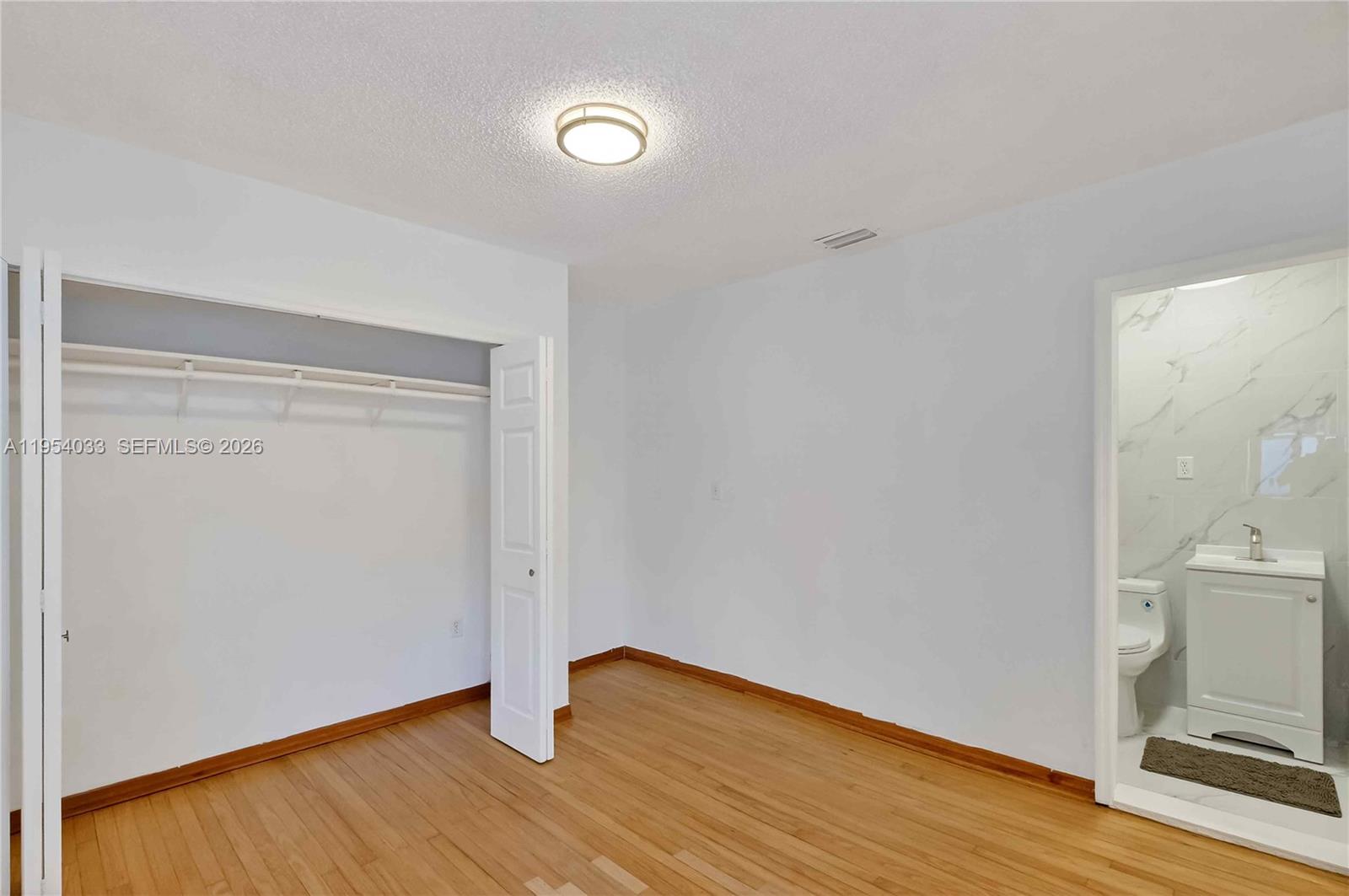 2399 Southwest 26th Lane Miami, FL 33133 - Photo 29 of 39 a view of an empty room with wooden floor and a fireplace