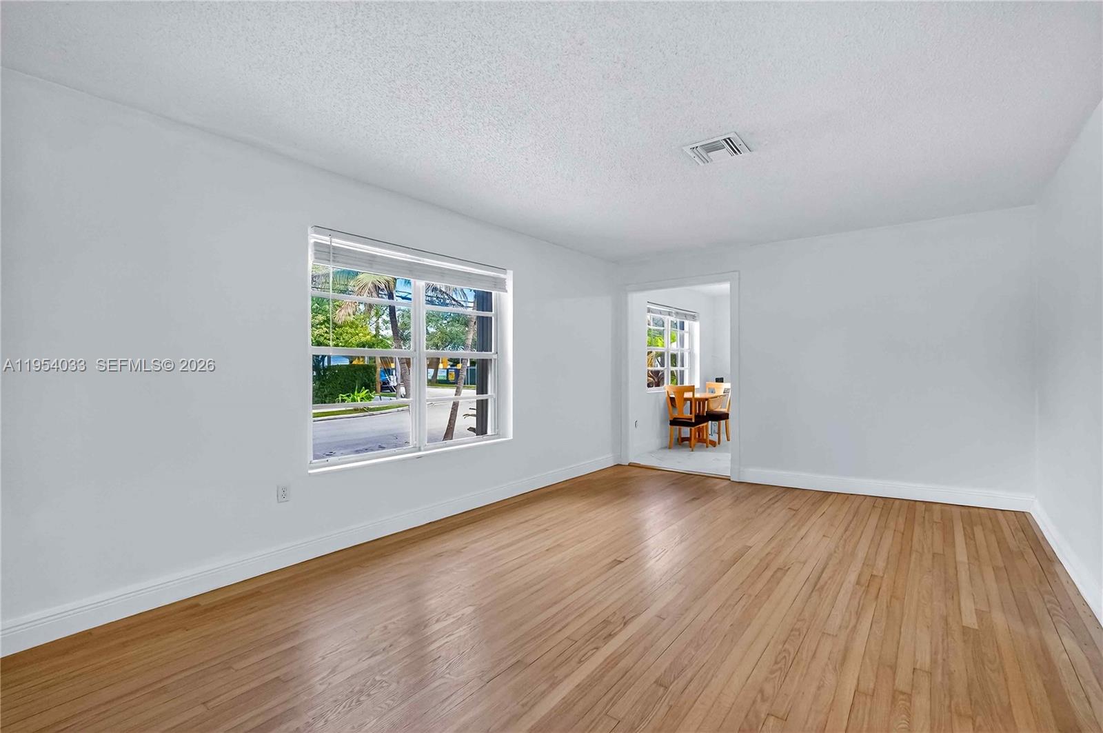 2399 Southwest 26th Lane Miami, FL 33133 - Photo 9 of 39 a view of an empty room with wooden floor and a window