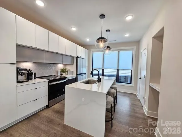 a kitchen with stainless steel appliances granite countertop a sink a stove and refrigerator