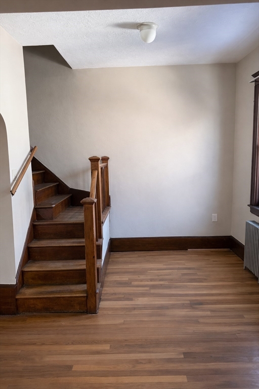 10 Orange Street, Unit 2 Chelsea, MA 02150 - Photo 11 of 17 a view of an empty room with wooden floor and stairs