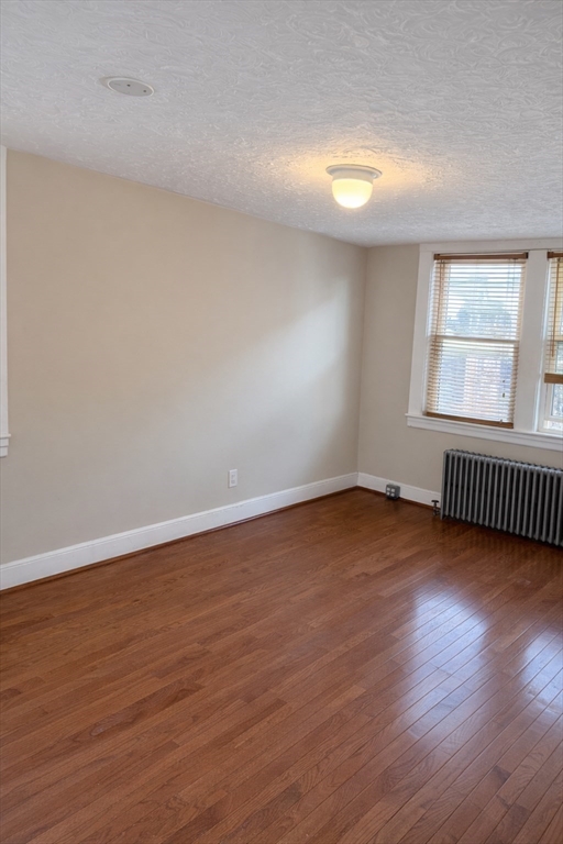 10 Orange Street, Unit 2 Chelsea, MA 02150 - Photo 12 of 17 a view of an empty room with wooden floor and window