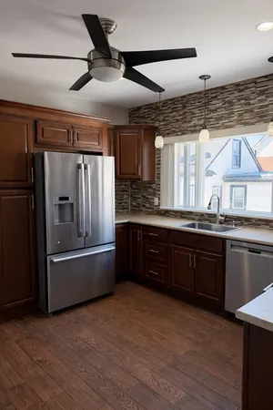 a kitchen with granite countertop a refrigerator and a sink