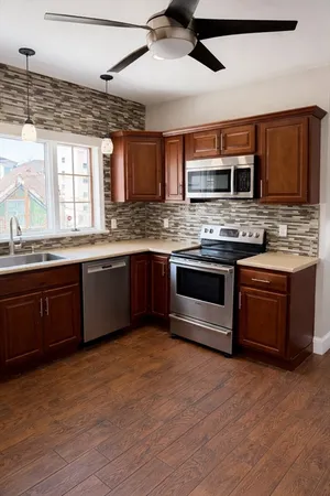 a kitchen with stainless steel appliances granite countertop a stove a sink and a microwave