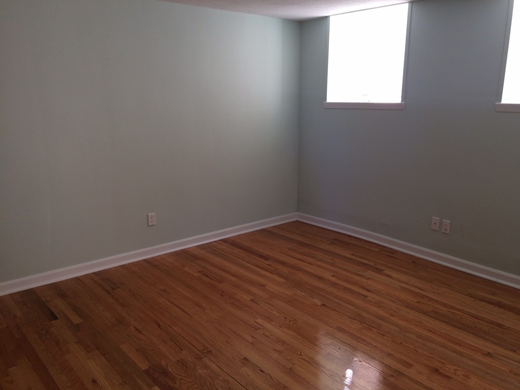 149 Winthrop Road, Unit 1 Brookline, MA 02445 - Photo 5 of 21 an empty room with wooden floor and windows