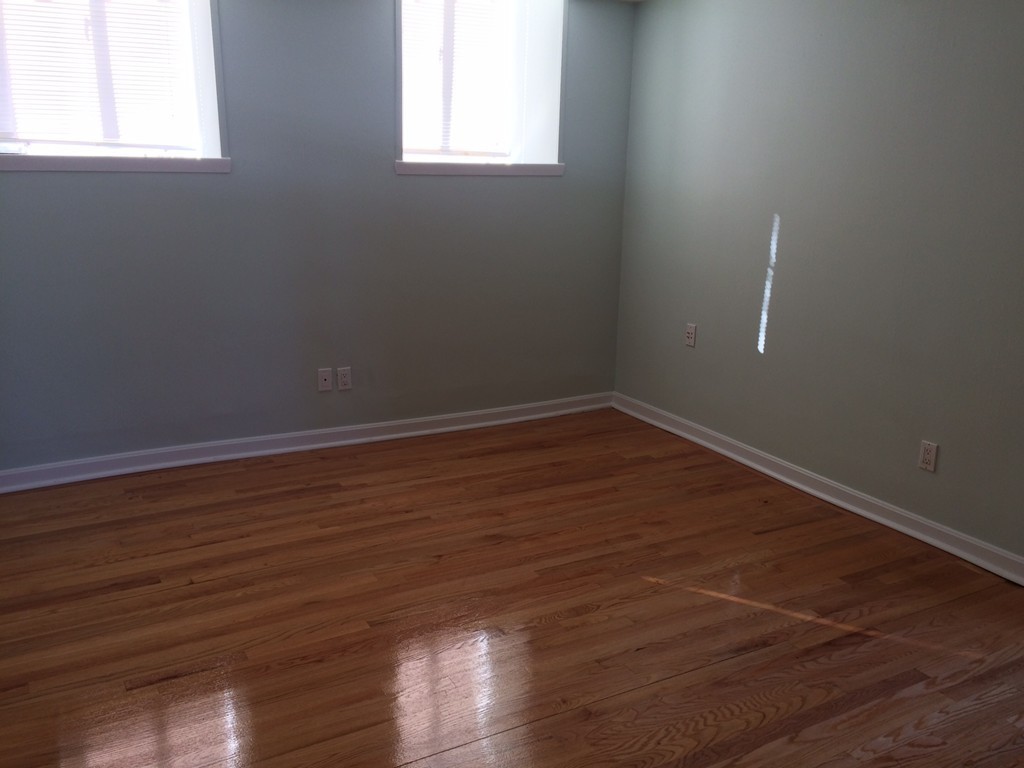 149 Winthrop Road, Unit 1 Brookline, MA 02445 - Photo 6 of 21 an empty room with wooden floor and windows