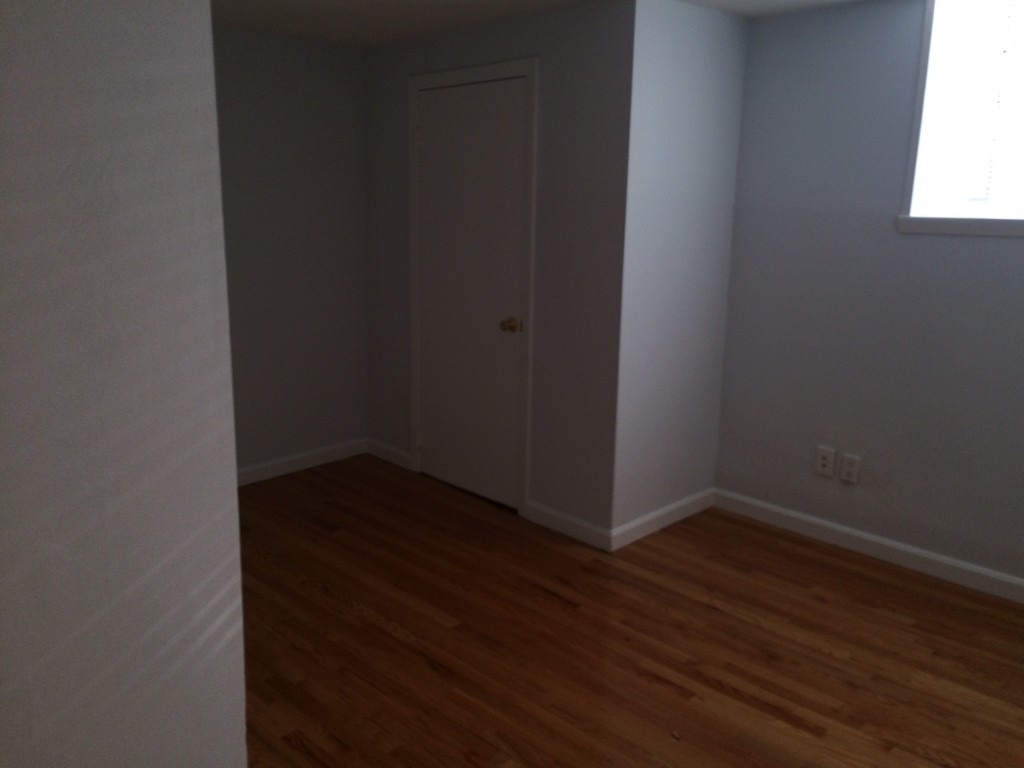 149 Winthrop Road, Unit 1 Brookline, MA 02445 - Photo 10 of 21 a view of an empty room with wooden floor and a window