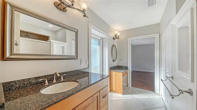 a bathroom with a granite countertop sink and a mirror