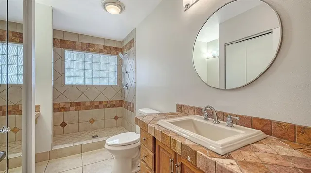 a bathroom with a sink a toilet and shower