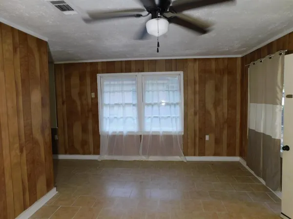 en empty room with windows and fan
