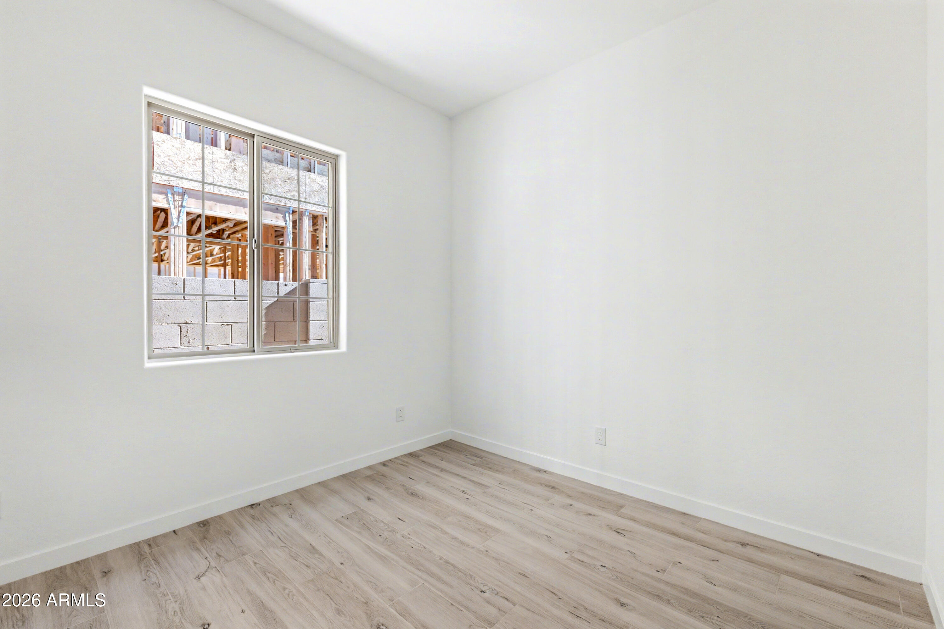 3618 East Roland Street Mesa, AZ 85213 - Photo 20 of 26 a view of an empty room with wooden floor and a window