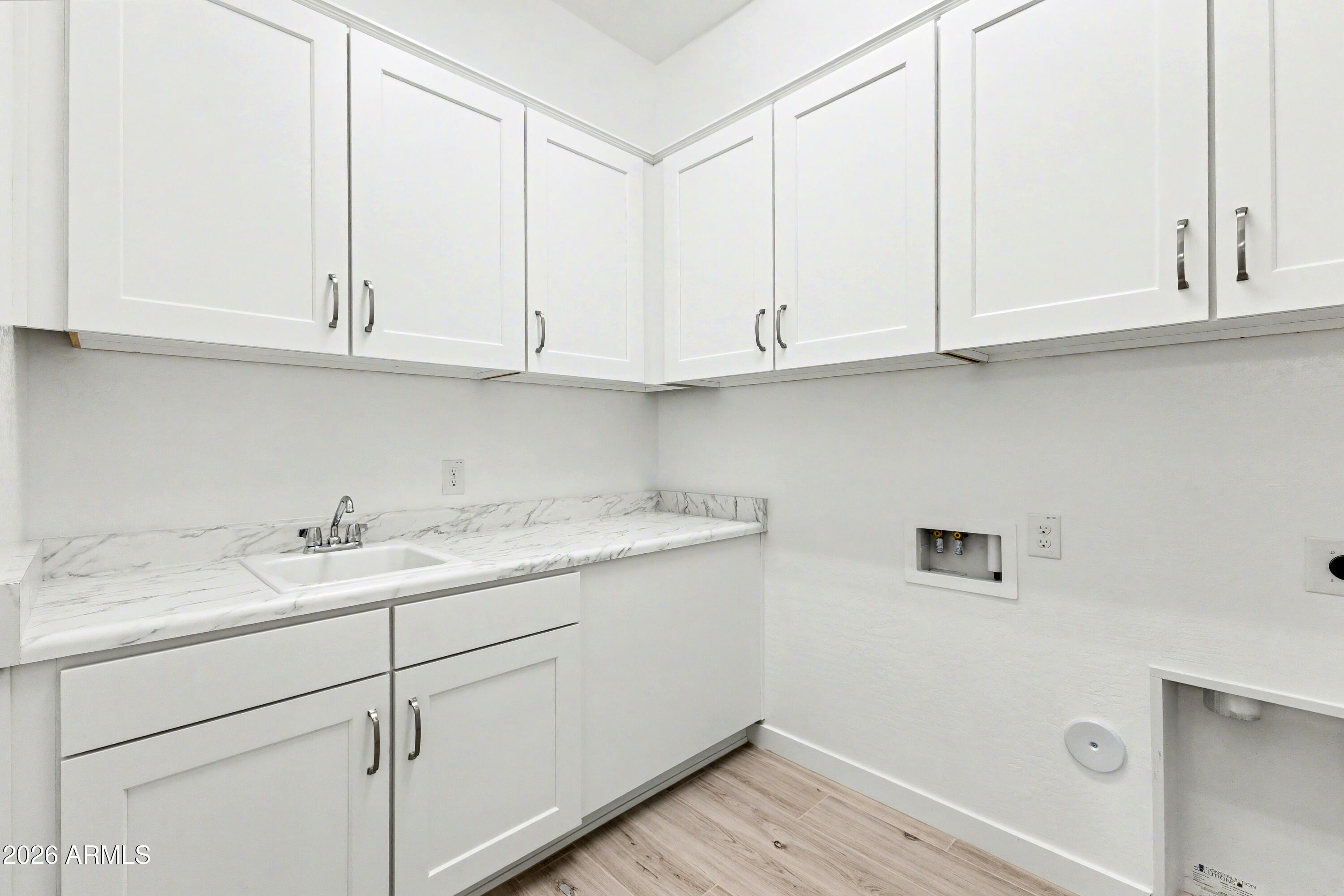 3618 East Roland Street Mesa, AZ 85213 - Photo 21 of 26 a kitchen with white cabinets and sink