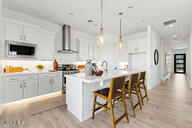 3618 East Roland Street Mesa, AZ 85213 - Photo 6 of 26 a kitchen with stainless steel appliances kitchen island granite countertop a table chairs sink and cabinets