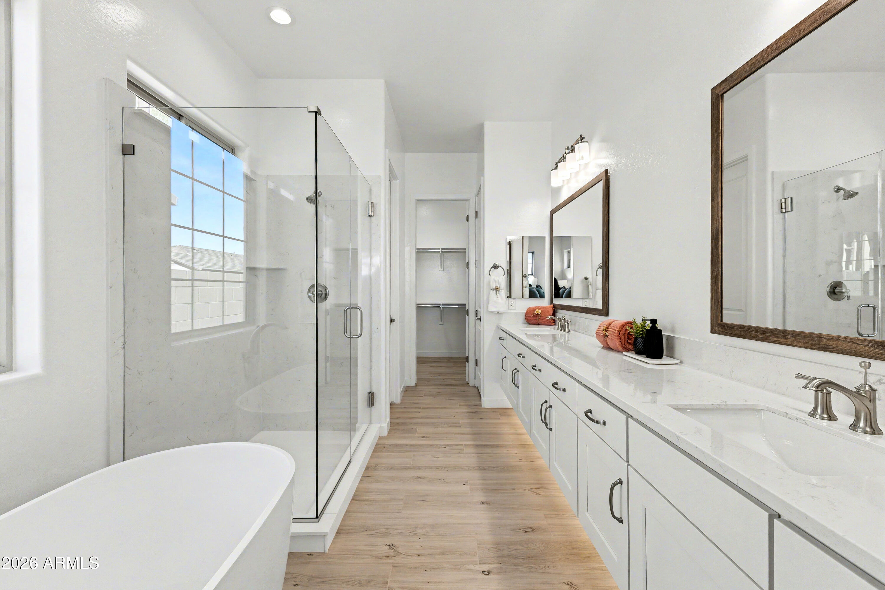 3618 East Roland Street Mesa, AZ 85213 - Photo 10 of 26 a large bathroom with a double vanity sink a mirror a bathtub and shower