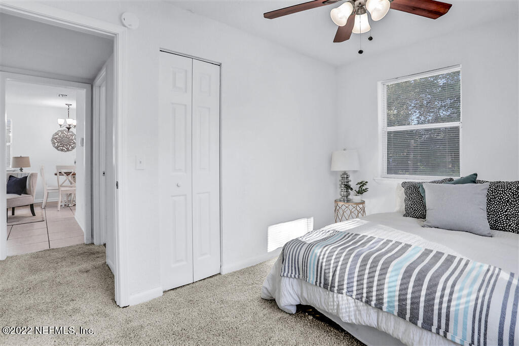 4657 Colchester Road Jacksonville, FL 32208 - Photo 14 of 23 a bedroom with a bed and a chandelier