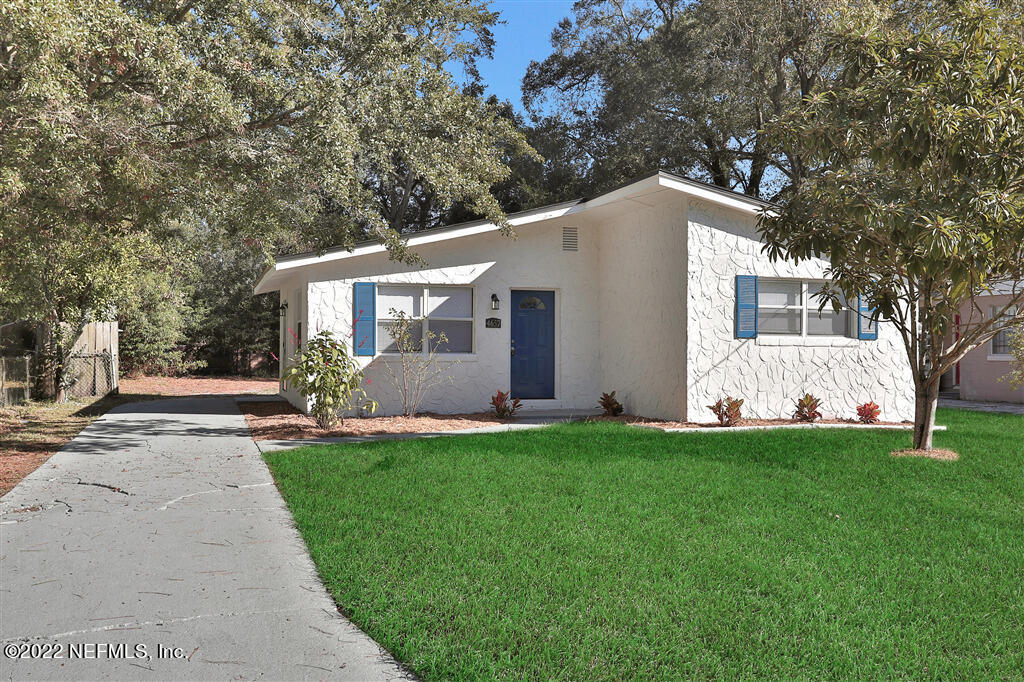 4657 Colchester Road Jacksonville, FL 32208 - Photo 2 of 23 a backyard of a house with potted plants and large tree