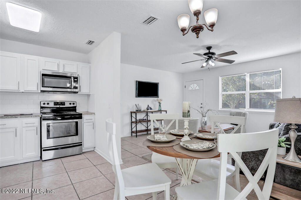 4657 Colchester Road Jacksonville, FL 32208 - Photo 7 of 23 a view of kitchen with microwave stove dining table and chairs