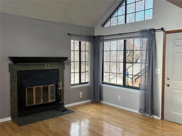 a view of an empty room with a fireplace and a window