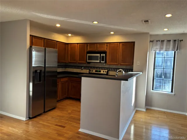 a kitchen with stainless steel appliances granite countertop a refrigerator and a stove
