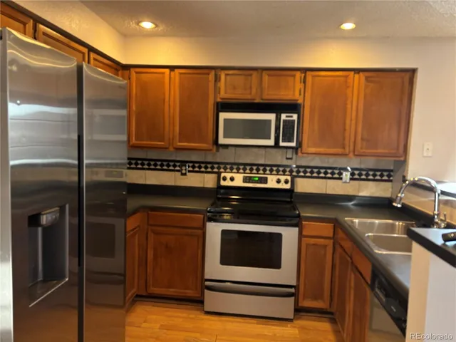 a kitchen with granite countertop a stove and a microwave