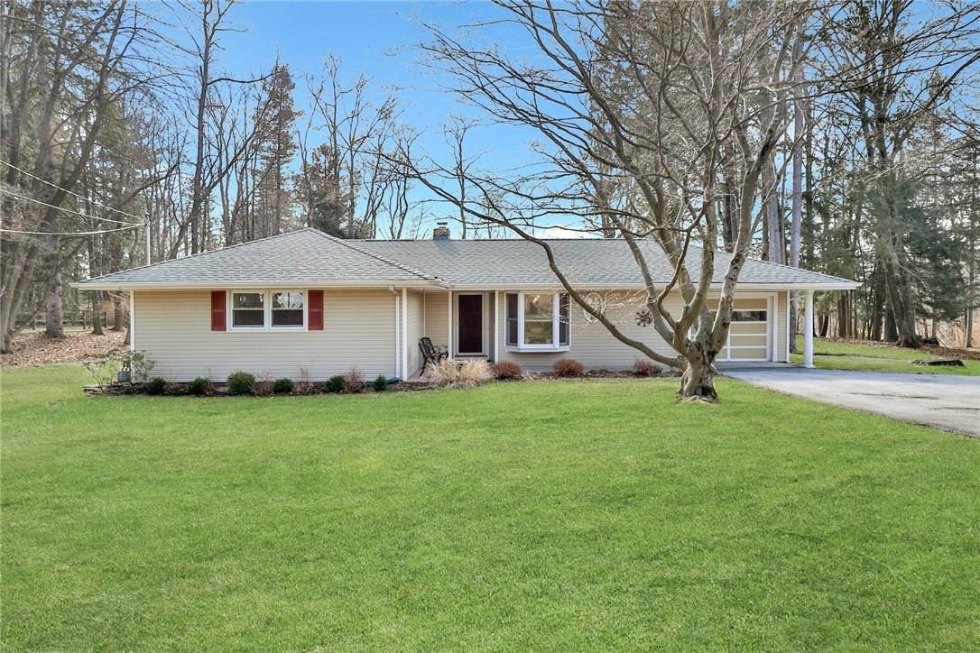 a view of a house with a big yard and large trees