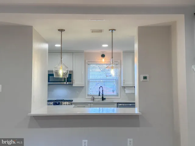 a view of a kitchen with wooden floor and a sink