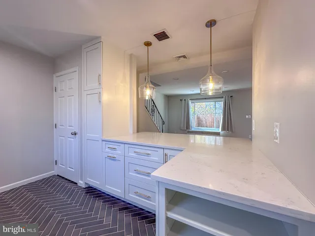 a kitchen with granite countertop white cabinets and white appliances