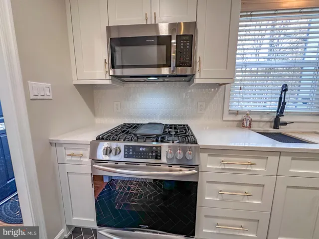 a stove top oven sitting inside of a kitchen